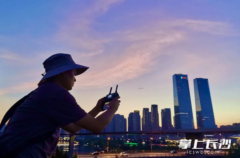摄影师在梅溪湖畔拍摄着如画美景。
