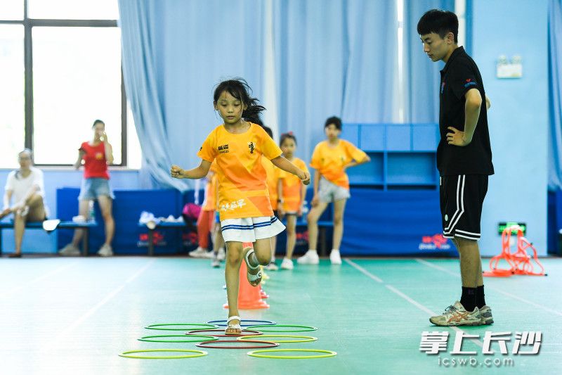 在谷山体育公园羽毛球馆，小朋友们在教练指导下进行羽毛球开练前的体能训练。 长沙晚报全媒体记者 黄启晴 摄