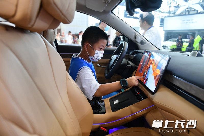 一位小朋友正在体验新能源车的高科技。长沙晚报全媒体记者 邹麟 摄
