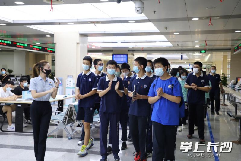 学生们在工作人员引导下，参观政务服务大厅。