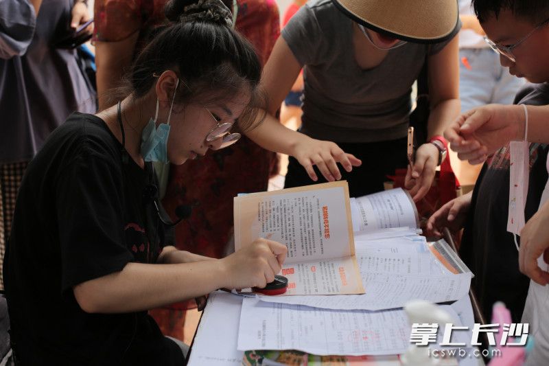 在景点，工作人员为学生的社会实践手册盖章。长沙晚报全媒体记者 刘琦 实习生 黄玲 摄影报道