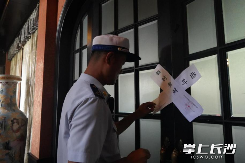 开福区消防监督员在包厢入口门上交叉粘贴封条。