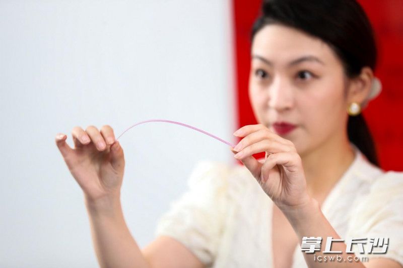 主持人在展示恩施来凤面条的韧性。 摄影 和际