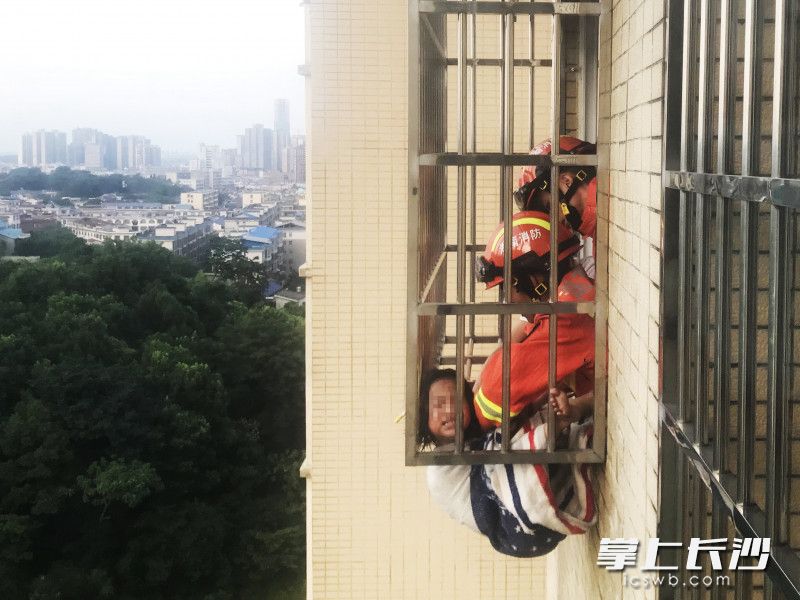 女童毛毛头部被卡在窗台防护栏里面，身体悬挂在外面，十分危险，消防救援人员到场后立即实施救援。均为长沙晚报通讯员 熊方圆 供图