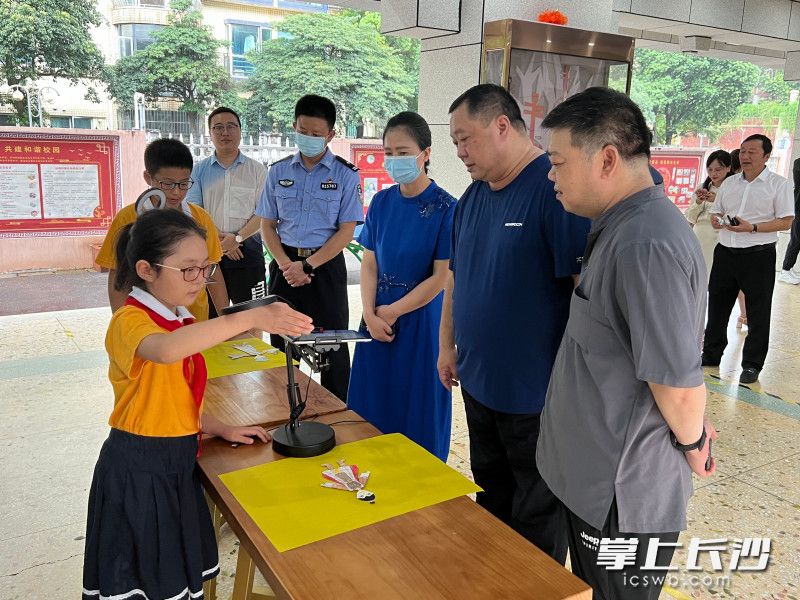 学生正在介绍定格动画禁毒短片《鸦片》的制作过程。