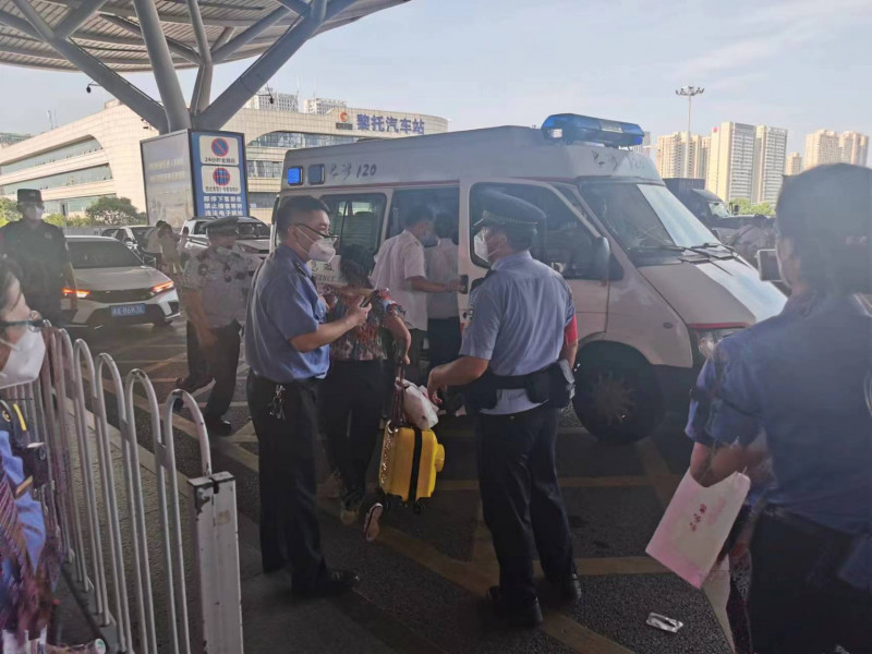 民警等人将男孩送上救护车。