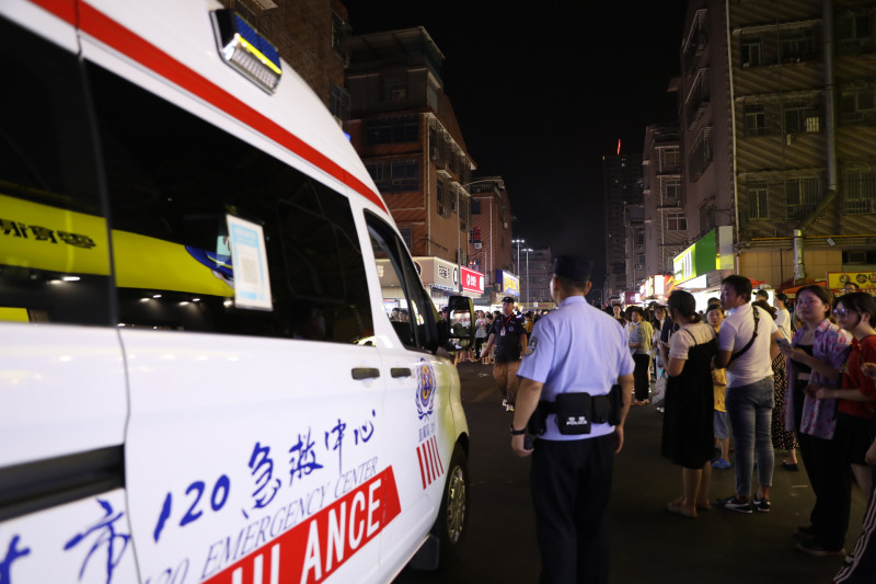 民警及保安人员帮忙疏散人群，为救护车开道。