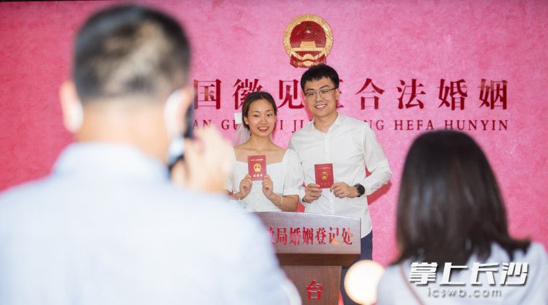 一对刚领证的年轻人正在拍照，脸上写满了幸福，家人朋友一起拍照记录美好时刻。长沙晚报全媒体记者 邹麟 实习生 易斯陶 摄