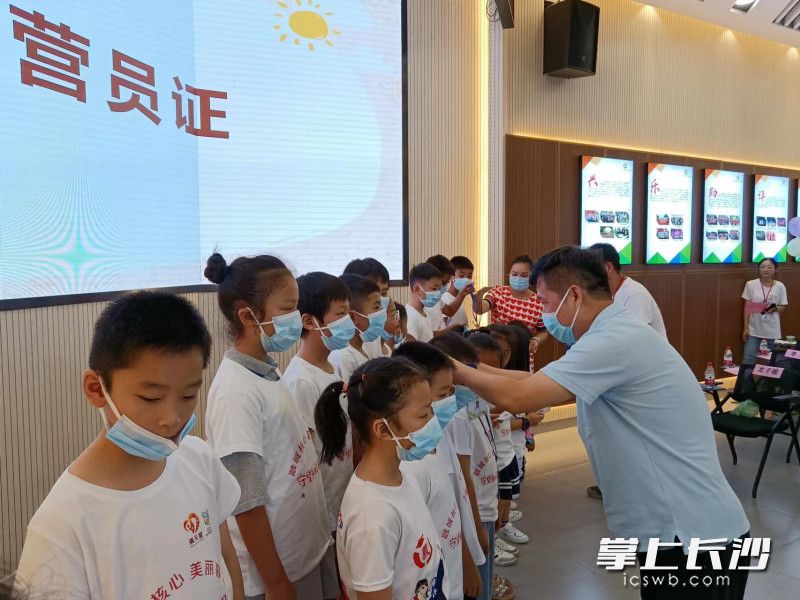 为参与活动的小朋友们颁发营员证。
