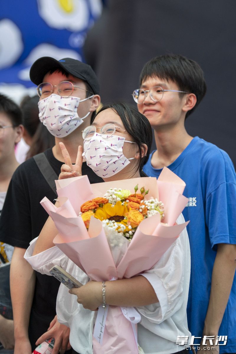 市民抱着鲜花在街头合影。