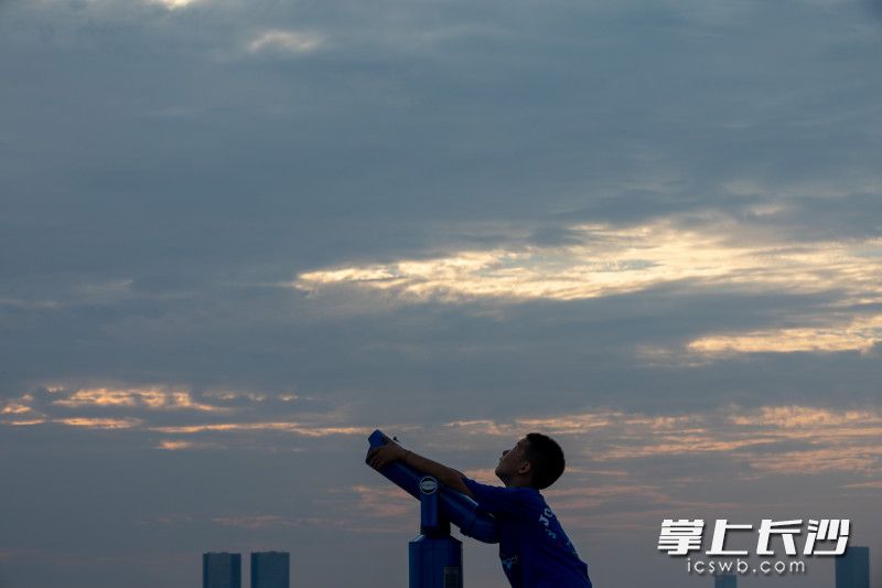 万家丽国际购物广场顶楼，一名小孩正在用望远镜观察天空。