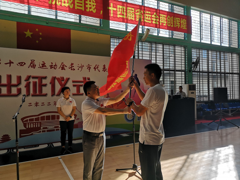 市体育局党组书记易冒向两支队伍授旗。