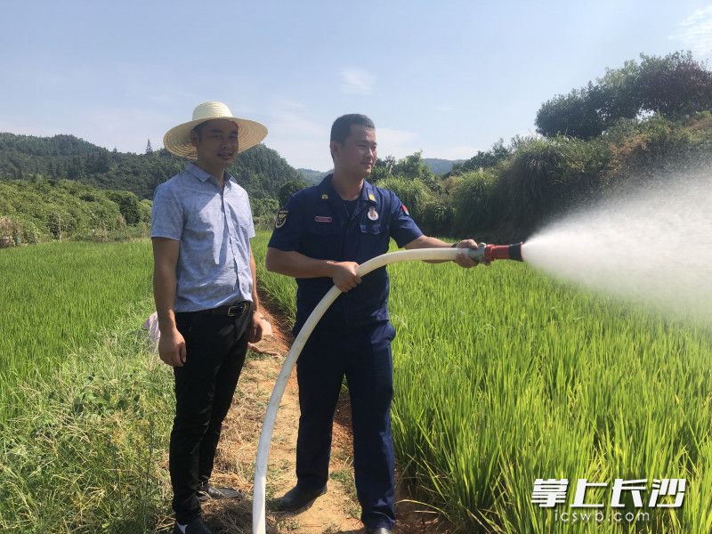 消防救援人员协助农户灌溉农田，缓解旱情。