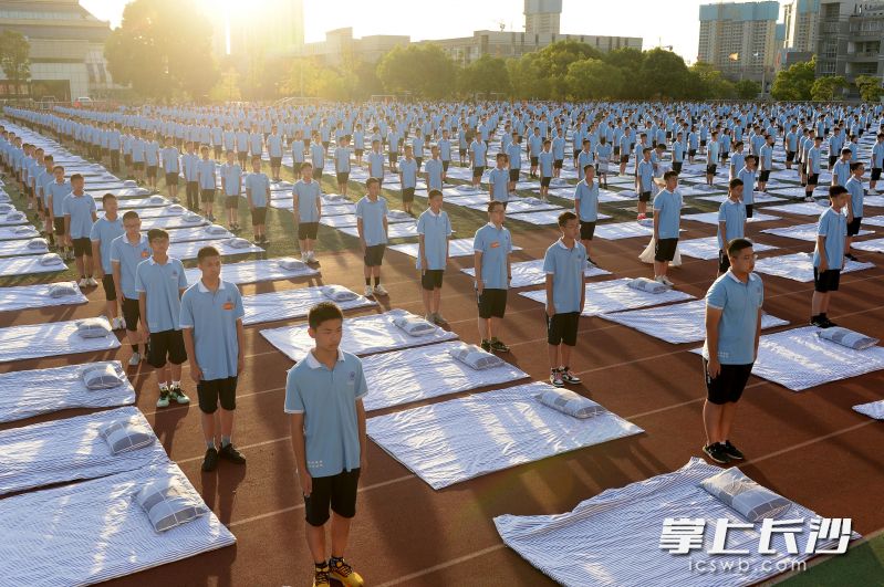 千人叠被比赛前，学子们带着被窝铺盖在操场摆开阵仗。
