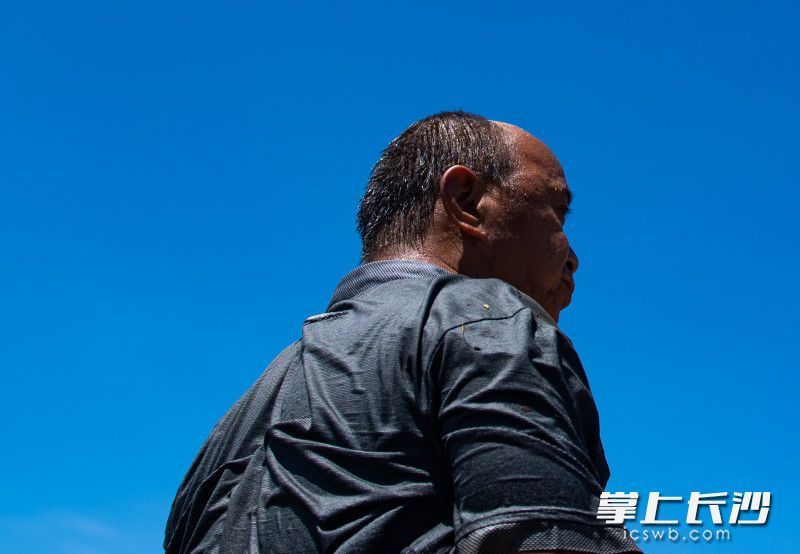 汗水加河水，连续几个小时紧张的工作，一位村民已全身湿透。