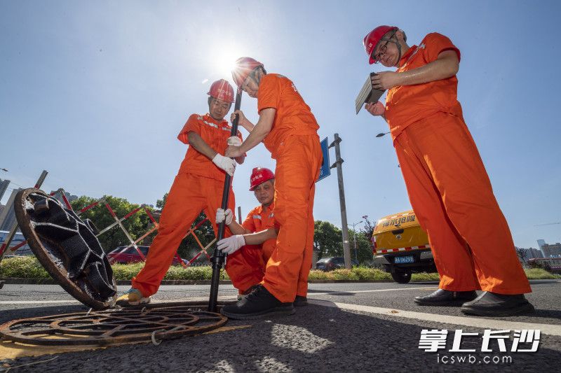 检查现场太阳直射毫无遮挡，滚滚热浪扑面而来，汗水浸湿了橙色的衣衫。