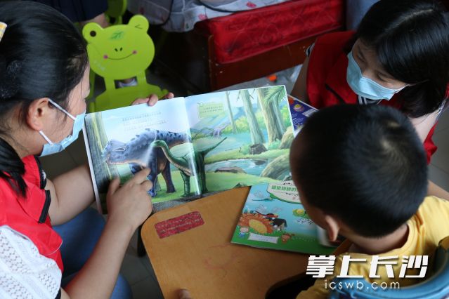 志愿者们给孩子们讲故事、玩游戏、做折纸，时不时发出一阵阵欢乐的笑声。