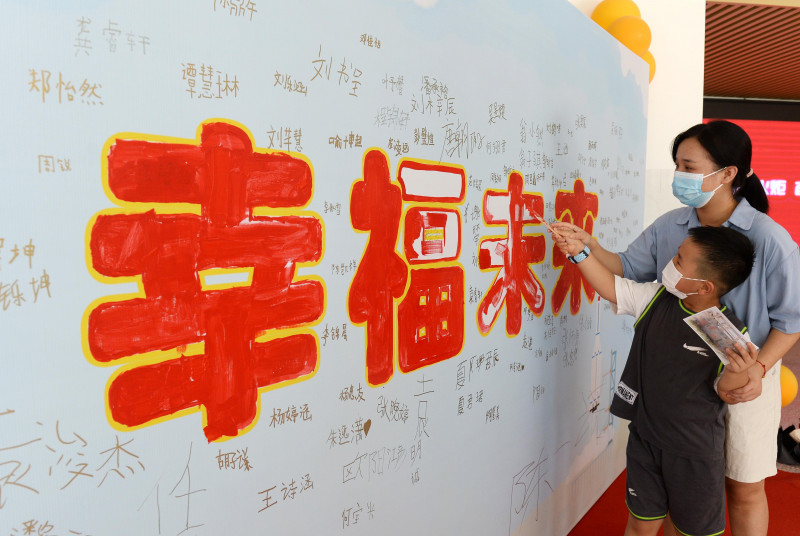 在老师的带领下，萌娃们来到“幸福未来”展板前开笔描红。
