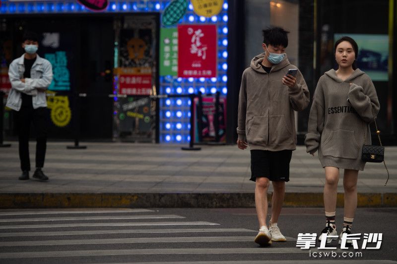 在黄兴南路，市民穿着各式衣服出行。