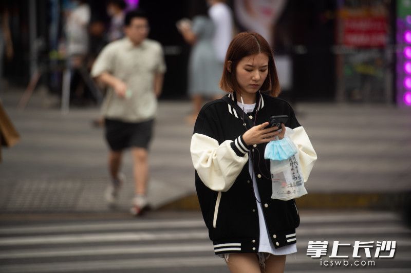 在黄兴南路，市民穿着各式衣服出行。