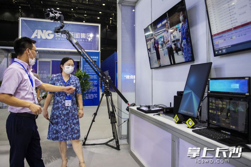 2022中国新媒体技术展上，一位展商正在给观展者介绍设备。长沙晚报全媒体记者 郭雨滴 摄