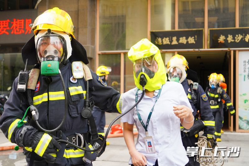 演练中，消防救援人员转移“被困群众”。