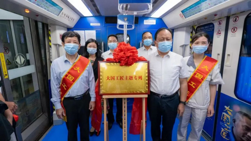 ▲周农与大国工匠艾爱国、易冉共同为主题专列揭牌。