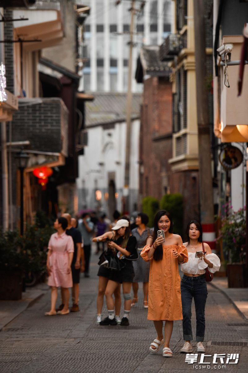 游客们漫步在青石板路的老街。