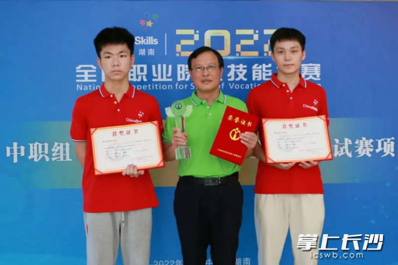 谭文彪（右）、周锋（左）赛后和指导老师合影。  均为市教育局供图