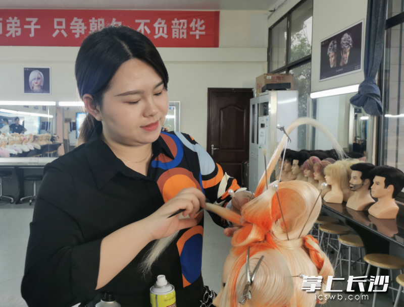 长沙财经学校老师余佳丽在练习美发。