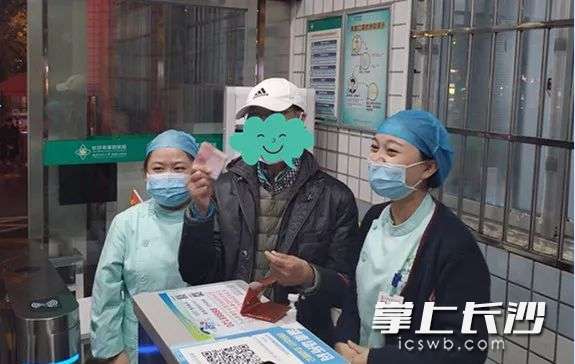 罗先生拿到失而复得的1800元钱，连声向拾金不昧的热心群众和医护人员道谢。长沙晚报通讯员 伍俊 摄