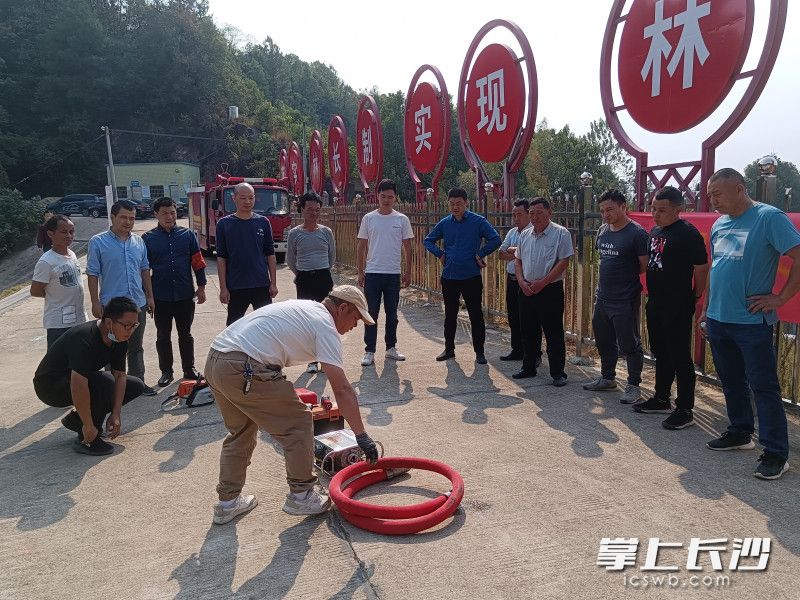 森林防火应急队伍的队员学习森林防灭火机械、设备的使用方法。