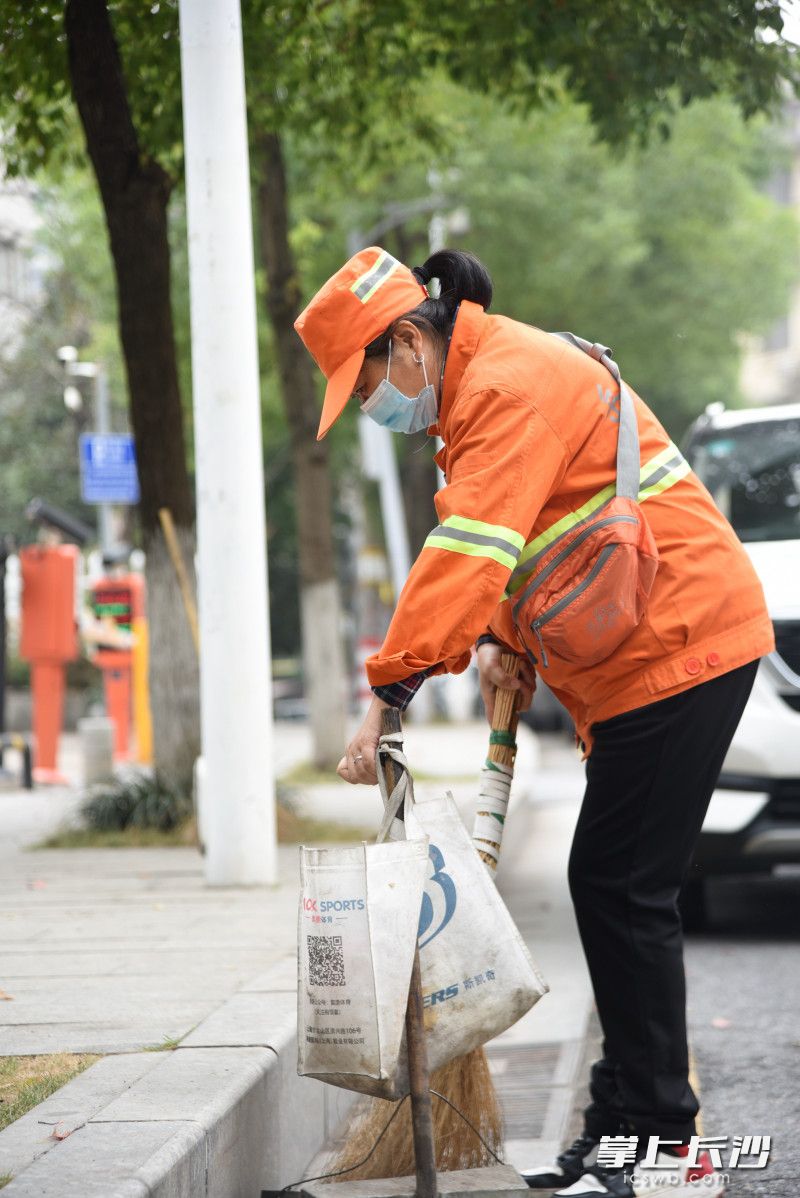 10月30日上午，环卫工人黄新生在岳华路上忙着打扫卫生。长沙晚报全媒体记者 刘琦 摄