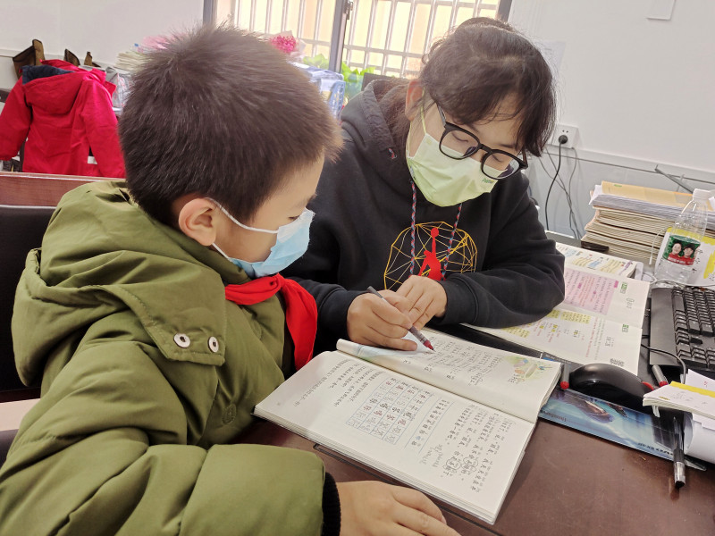 小宇复课后，李媛老师利用课余时间帮小宇把落下的课程补上。学校供图