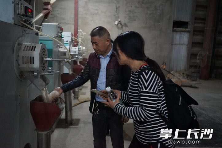师生团队在沅江的大米加工生产车间与工作人员交流探讨。