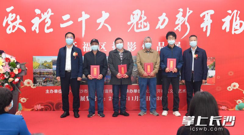 11月27日，“献礼二十大 魅力新开福”摄影作品展在开福区政府一楼大厅展出。图为与会领导给获奖摄影师颁奖。长沙晚报全媒体记者 邹麟 摄