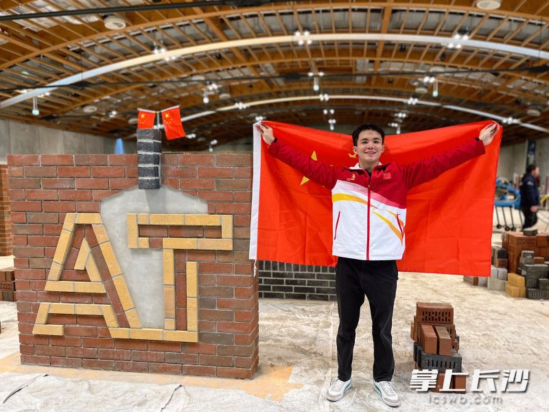 中建五局高级技校（长沙建校）教师伍远州成功摘得砌筑项目金牌，图为他在现场与作品合照。照片由学校提供。