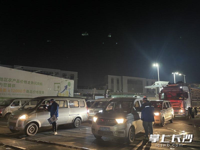 长沙海吉星入口，车辆井然有序入场，现场工作人员、来货采购车辆都严格落实疫情防控措施。