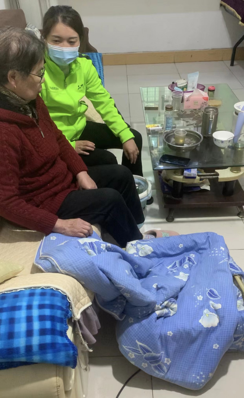 站内康复医生上门访问高龄独居老人皮爱珍，为她查看腿脚疼痛原因及水肿程度。