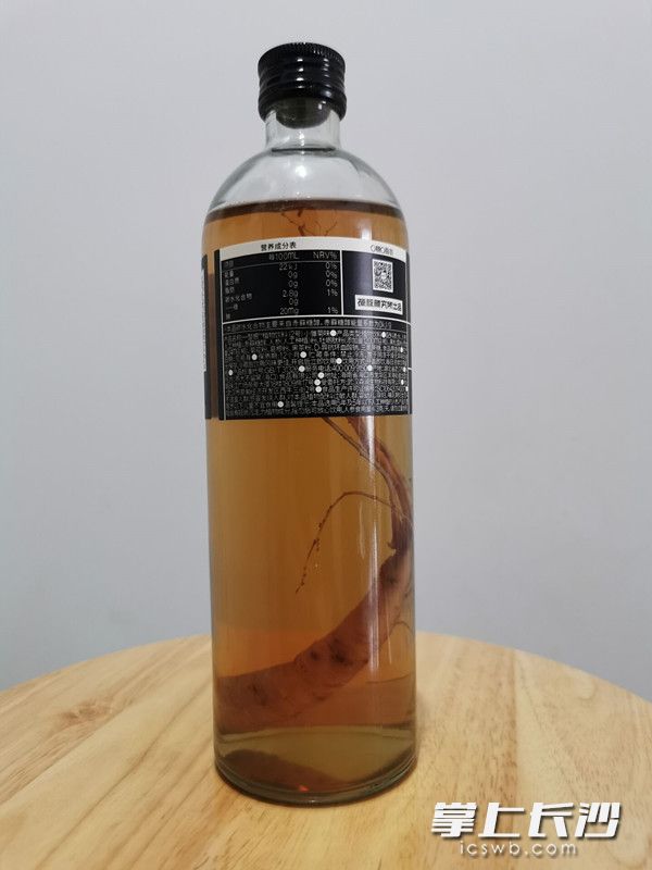 这款售价近20元一瓶的淡黄色植物饮料，最大的卖点是一整根人参。  长沙晚报全媒体记者 刘树源 摄