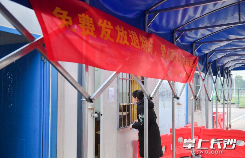 发热居民正在窗口取药。