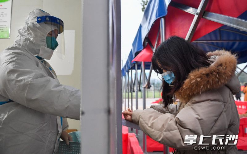 梅溪湖街道社区卫生服务中心医护人员正在为发热居民免费发放退烧药。