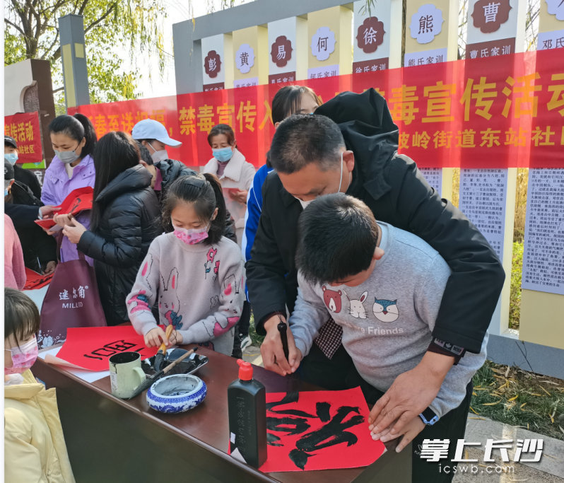 翰墨飘香，书法班成员手把手教小朋友写福字。长沙晚报通讯员 刘美吟 摄