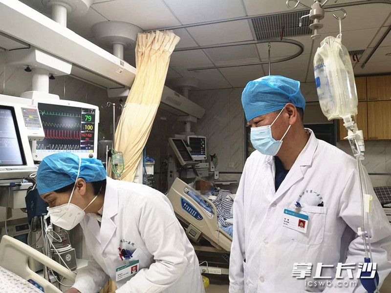 刘敏与同为医生的爱人——妇科副主任、副主任医师陈喜云（左）一起为重症患者进行会诊。