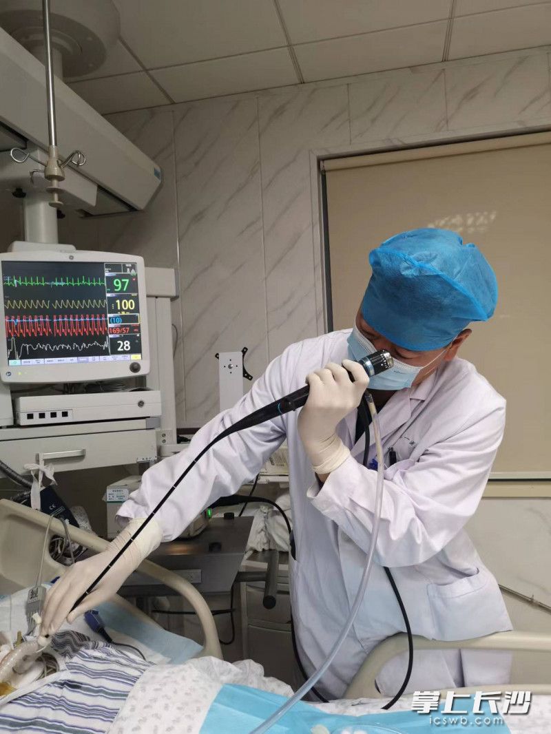 刘敏采用纤维支气管镜在床旁为重症患者吸痰。