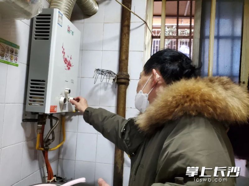 罗小平师傅帮居民检修热水器。  长沙晚报全媒体记者 颜家文 摄