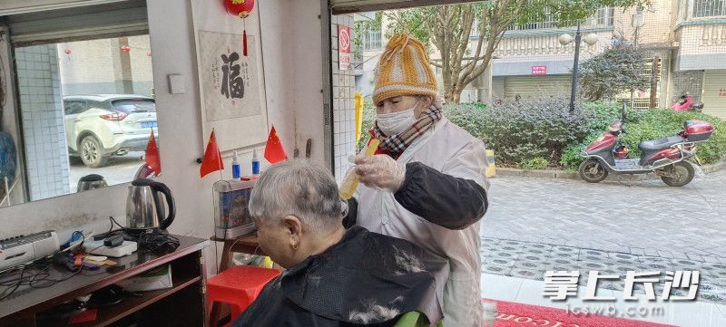 唐金连在给居民理发。  均为长沙晚报全媒体记者邓艳红摄