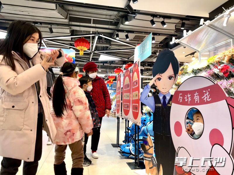 家长们带着孩子看反诈谜语，猜谜题。