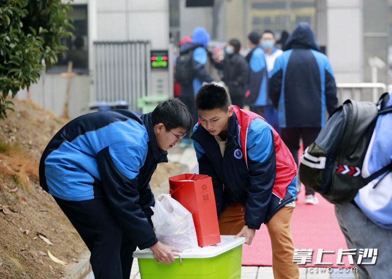 学生志愿者正在帮助返校学子转运行李。