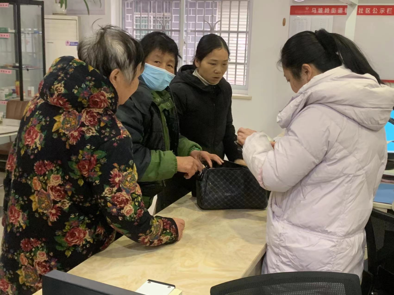 廖利双（左二）冒雨把捡到的包送到社区。均为长沙晚报通讯员 许浩铭 摄